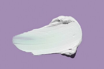 Cosmetic face or body thin cream hair balm purple colored background