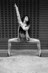 full body of young woman dancing ballet, wearing ballet shoes, shorts and casual top, modern urban style ballerina lifestyle, beauty and art in black and white © Alejandro