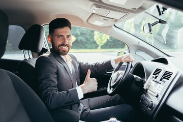 Businessman shows thumbs up and looks at the camera with a smile urges to pinch and use the seat...