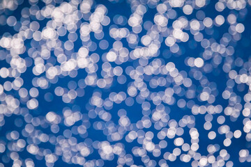 Lights on blue background. White bokeh on a blue background.