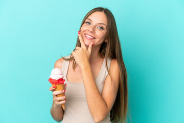 Young Lithuanian woman with cornet ice cream isolated on blue background happy and smiling