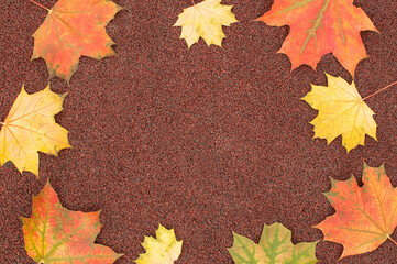 Naklejka na ściany i meble autumn brown background with red and yellow maple leaves on the edges of the frame with space for text