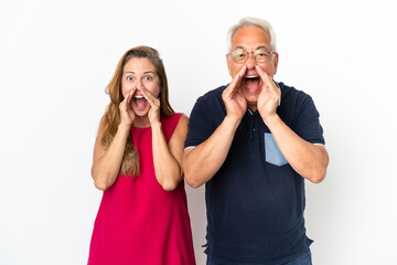 Middle age couple isolated on white background shouting with mouth wide open