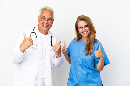 Middle age doctor and nurse isolated on white background giving a thumbs up gesture with both hands and smiling