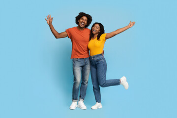 Happy african american lovers embracing over blue studio background