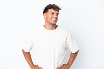 Obraz premium Young caucasian handsome man isolated on white background posing with arms at hip and smiling