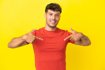 Young caucasian handsome man isolated on yellow background proud and self-satisfied