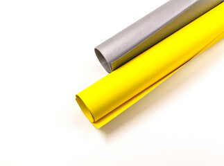 Rolls of paper in yellow and gray.