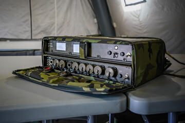 Military grade ruggedized ethernet network switch on a desk in army tent, closeup detail