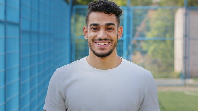 Attractive middle eastern indian young male athlete standing in stadium in sportswear waving hand welcoming newcomer athletes fans, arabic sports guy inviting to join team promoting active lifestyle