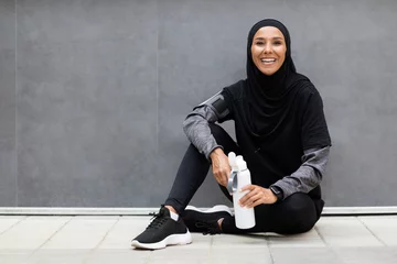 Keuken spatwand met foto Wellness Concept. Sporty Young Muslim Woman Relaxing After Fitness Training Outdoors © Prostock-studio