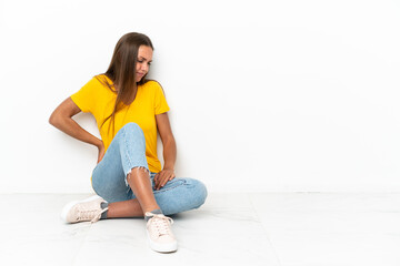 Young girl sitting on the floor suffering from backache for having made an effort