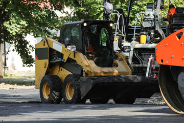 Modern skid loader on city street. Road repair service