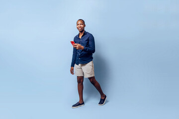 full body of african young man using a mobile phone online app technology concept over a background.
