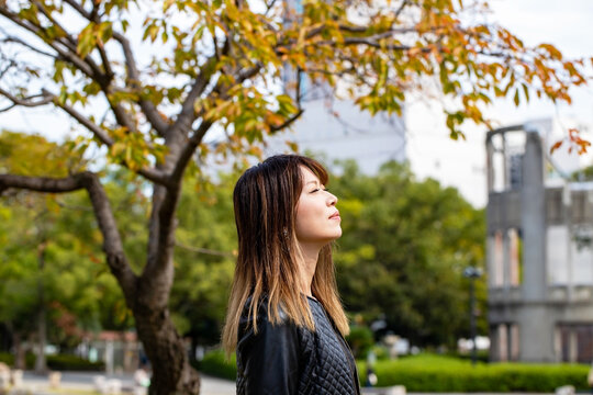 広島市の平和記念公園で目を閉じて上を向く女性