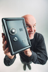 Gleeful man holding up a small safe with combination lock