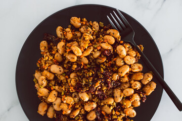 vegan sauted cauliflower rice and butter beans with sundried tomatoes and herbs, healthy plant-based food