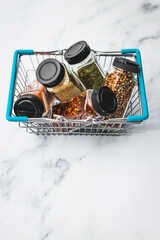 spices and seasonings in matching spice jars in ngrocery shopping basket, simple vegan ingredients and flavoring your dishes