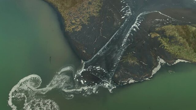 Aerial: Ocean water flowing into an Estuary,, Awakino, Waitomo, New Zealand