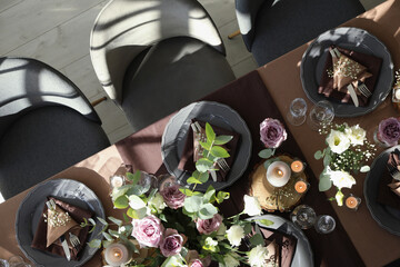 Festive table setting with beautiful tableware, candles and floral decor indoors, top view