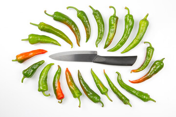 ceramic knife and green hot peppers on a white background. cooking vegetables for food