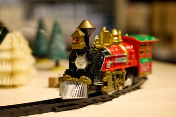 Vintage steam locomotive Christmas toy on the railroad, home decore with golden, black, green colors