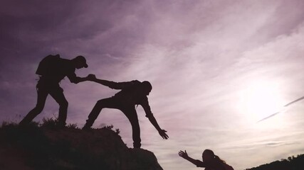teamwork help business travel silhouette concept. group team of tourists lends a helping hand climb lifestyle the cliffs mountains. teamwork people climbers climb to top lifestyle overcoming hardships