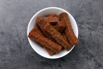 Crispy rusks in bowl on grey table, top view
