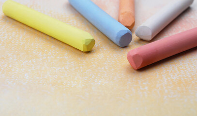 Colorful pastel chalks on abstract painting, closeup. Drawing materials