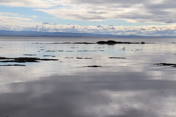River and landscape. Low tide in Charlevoix. Charlevoix and Quebec tourism. Reflect of water. Sky and river. Cloudy. Horizon and peaceful.  St-Laurent river in Quebec. Reflection, water and sky.