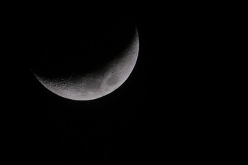 Crescent moon in dark winter sky with black background