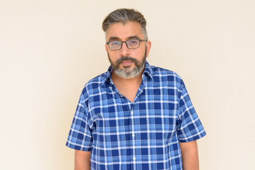 Obraz premium Portrait of bearded Indian businessman against plain background