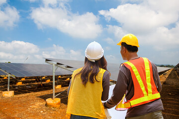 Engineer inspector male and female working in solar panel electric farm. photovoltaic cell park green energy concept