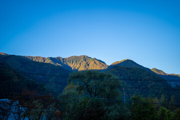 霞沢岳、乗鞍岳、上高地、穂高岳などを見るために、長野県松本市の晩秋の雪が積もる焼岳を登山する風景 Scenery of climbing Mt. Yakedake with snow in late autumn in Matsumoto, Nagano Prefecture to see Mt. Kasumisawa, Mt. Norikura, Kamikochi and Mt. Hodaka