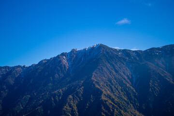 霞沢岳、乗鞍岳、上高地、穂高岳などを見るために、長野県松本市の晩秋の雪が積もる焼岳を登山する風景 Scenery of climbing Mt. Yakedake with snow in late autumn in Matsumoto, Nagano Prefecture to see Mt. Kasumisawa, Mt. Norikura, Kamikochi and Mt. Hodaka