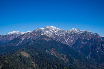 Fototapeta premium 霞沢岳、乗鞍岳、上高地、穂高岳などを見るために、長野県松本市の晩秋の雪が積もる焼岳を登山する風景 Scenery of climbing Mt. Yakedake with snow in late autumn in Matsumoto, Nagano Prefecture to see Mt. Kasumisawa, Mt. Norikura, Kamikochi and Mt. Hodaka
