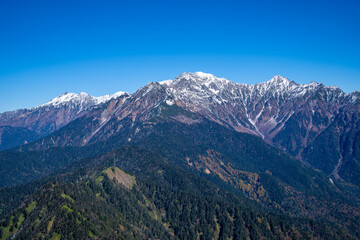 霞沢岳、乗鞍岳、上高地、穂高岳などを見るために、長野県松本市の晩秋の雪が積もる焼岳を登山する風景 Scenery of climbing Mt. Yakedake with snow in late autumn in Matsumoto, Nagano Prefecture to see Mt. Kasumisawa, Mt. Norikura, Kamikochi and Mt. Hodaka