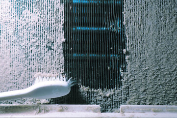 Tooth brush cleaning thick dust on air conditioner coil - obrazy, fototapety, plakaty