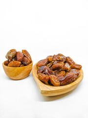 Fresh and healty premium honey tunisia dates (kurma tunisia) in a wooden bowl isolated on white background