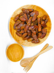 Fresh and healty premium honey tunisia dates (kurma tunisia) in a wooden bowl isolated on white background