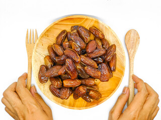 Fresh and healty premium honey tunisia dates (kurma tunisia) in a wooden bowl isolated on white background