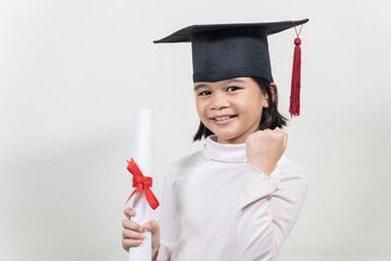 Portrait of a cute happy Asian school kid graduate with graduation hat and a diploma isolated on...