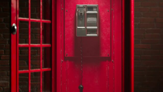 Black handset hanging in a red telephone box. Footage with a British phone booth