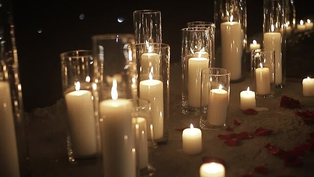 Algunas velas ardiendo oscuridad sobre p&eacute;talos de rosa, evento de propuesta de matrimonio