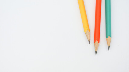 Pencils placed on white paper background with copy space for your image or text.