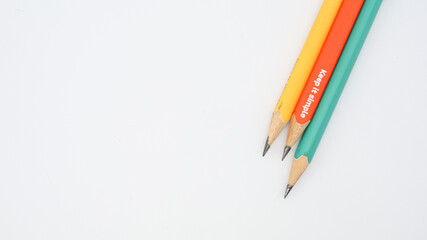 Pencils placed on white paper background with copy space for your image or text.