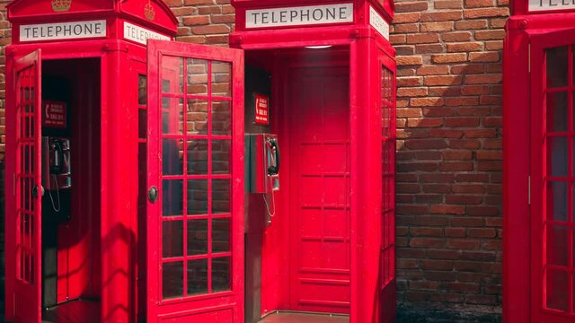 Footage with  British red phone booths. Close up on hanging receiver on the wall
