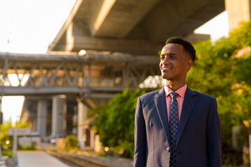 Portrait of successful young African businessman wearing suit and tie while thinking