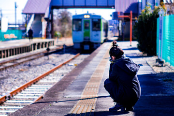 ローカル線の列車を撮影するカメラ女子