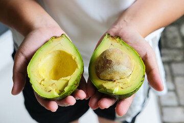 Person hand showing delicious peeled avocado fruit
